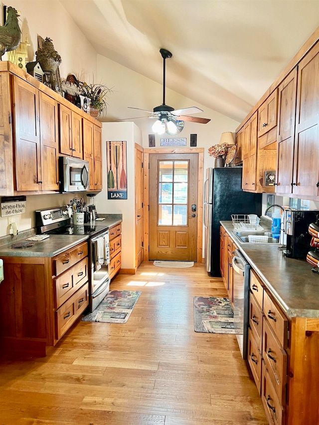 kitchen featuring light wood-type flooring, ceiling fan, vaulted ceiling, sink, and stainless steel appliances