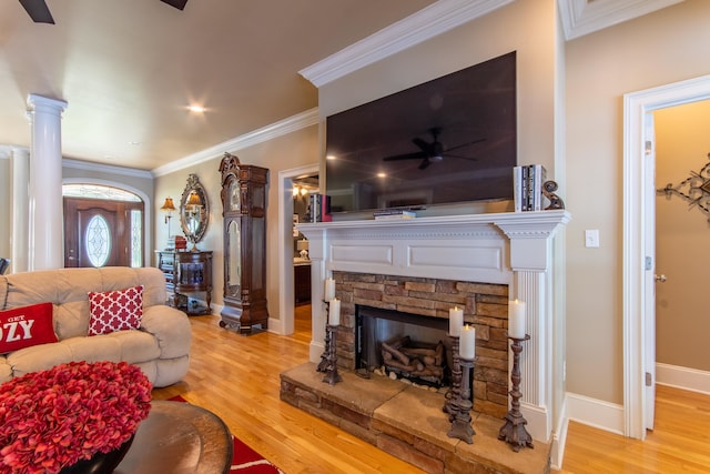 living room with ornamental molding, a fireplace, ornate columns, and light hardwood / wood-style floors