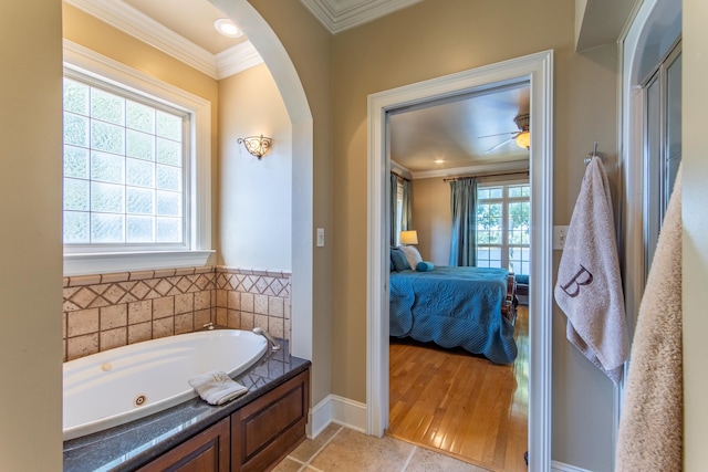 bathroom with ornamental molding, a healthy amount of sunlight, ceiling fan, and wood-type flooring