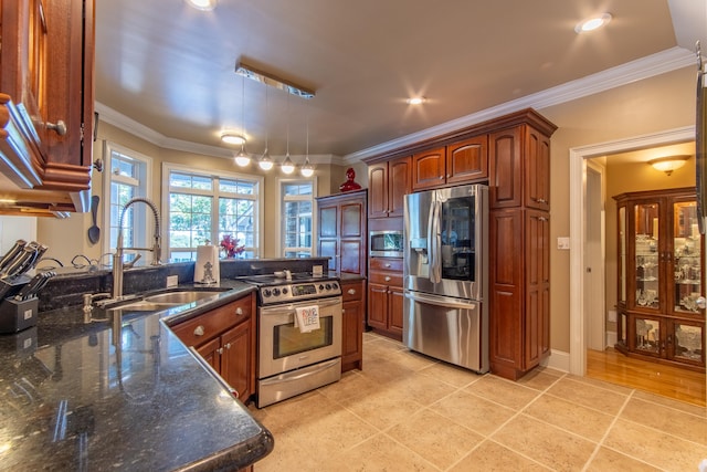 kitchen with dark stone countertops, ornamental molding, appliances with stainless steel finishes, and sink