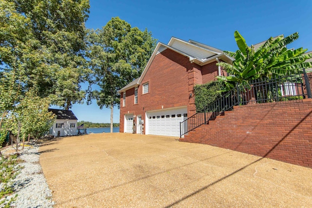 view of side of home featuring a water view and a garage