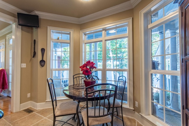 tiled dining area with plenty of natural light and crown molding