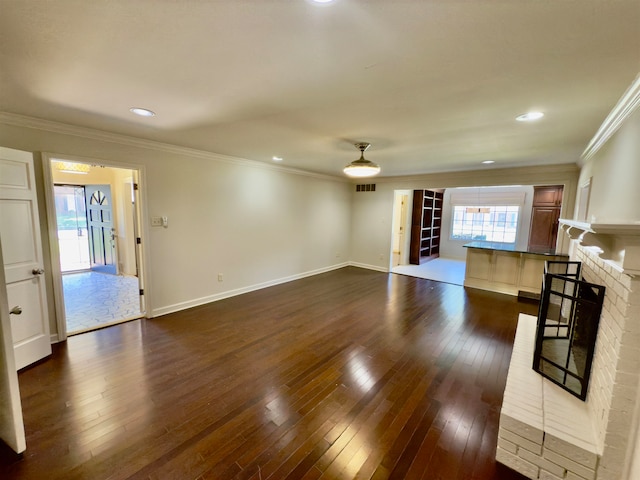 living room featuring ornamental molding, dark hardwood / wood-style floors, and a brick fireplace