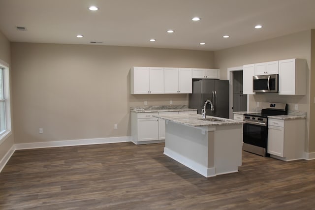 kitchen featuring a kitchen island with sink, white cabinetry, stainless steel appliances, dark hardwood / wood-style floors, and light stone countertops