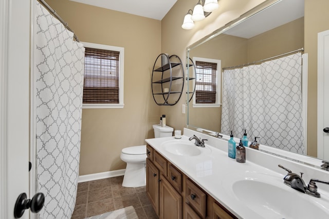 bathroom with a healthy amount of sunlight, tile patterned floors, vanity, and toilet