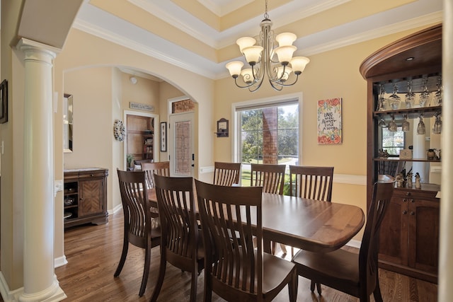 dining area with a chandelier, decorative columns, crown molding, and dark hardwood / wood-style flooring