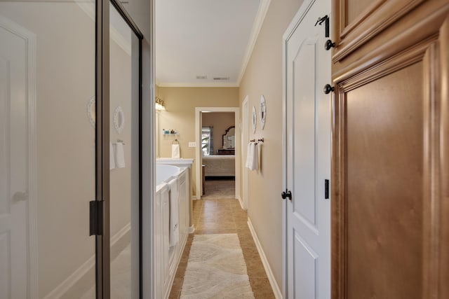 hall with crown molding and light tile patterned floors