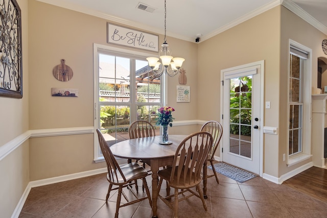 tiled dining space featuring a chandelier, ornamental molding, and a wealth of natural light