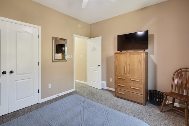 bedroom featuring dark colored carpet, ceiling fan, and a closet