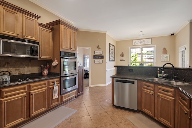 kitchen featuring light tile patterned flooring, sink, ornamental molding, decorative light fixtures, and appliances with stainless steel finishes