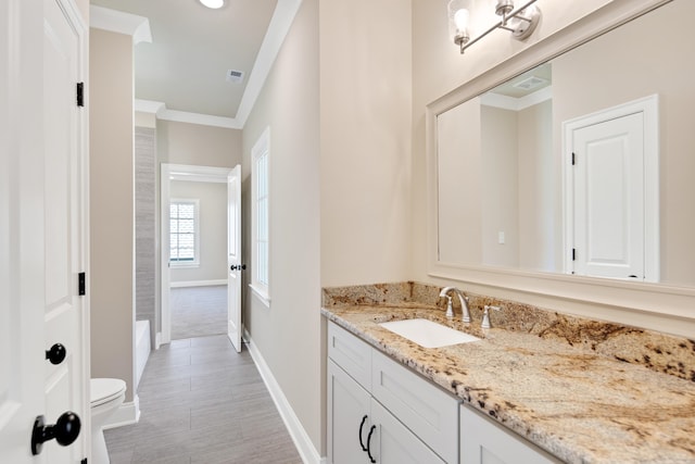 bathroom with ornamental molding, vanity, and toilet