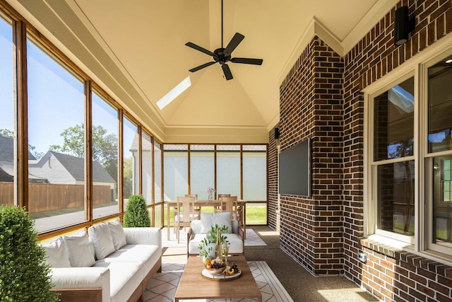 unfurnished sunroom featuring lofted ceiling with skylight, a healthy amount of sunlight, and ceiling fan