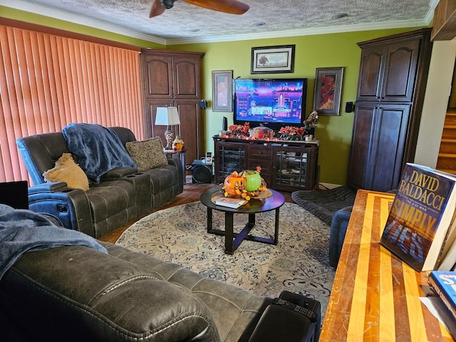 living room featuring ornamental molding, ceiling fan, hardwood / wood-style floors, and a textured ceiling