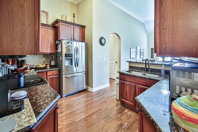 kitchen with ornamental molding, sink, light wood-type flooring, and stainless steel fridge