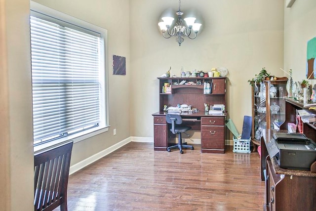 office with wood-type flooring and an inviting chandelier