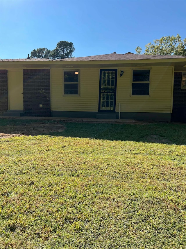 back of property featuring a lawn