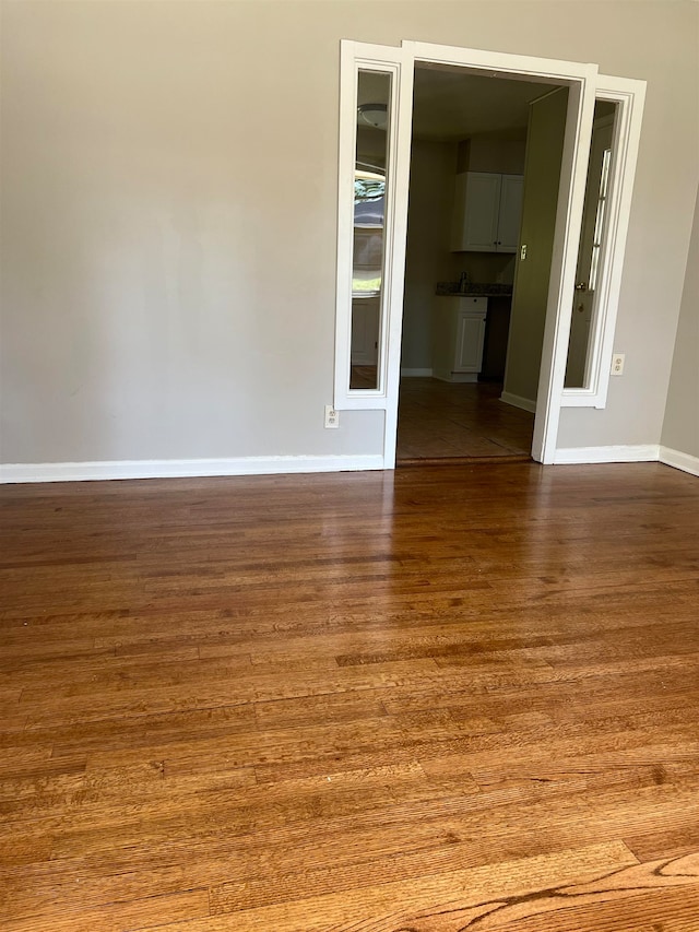 spare room with wood-type flooring and sink