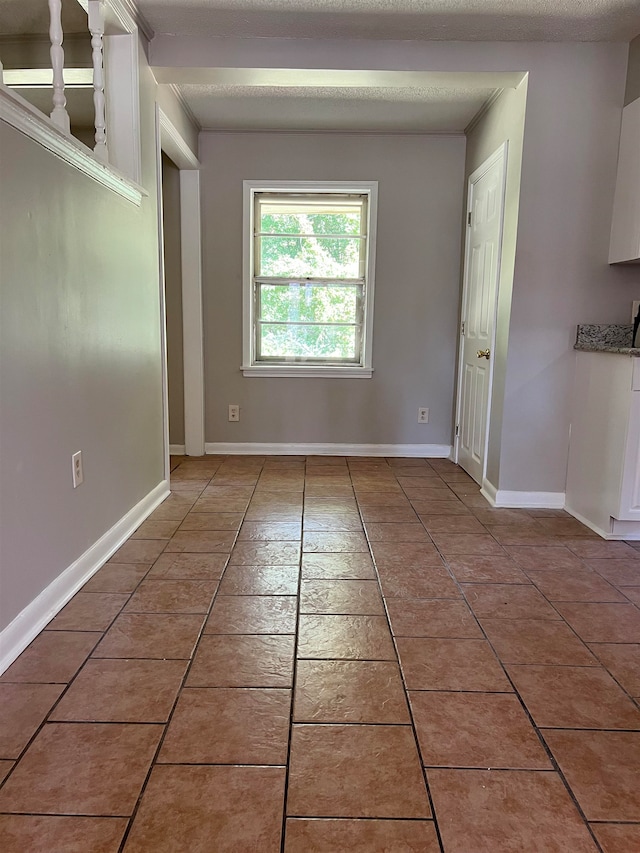 tiled empty room with a textured ceiling