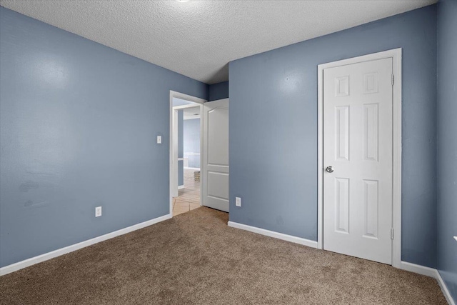 unfurnished bedroom featuring carpet and a textured ceiling