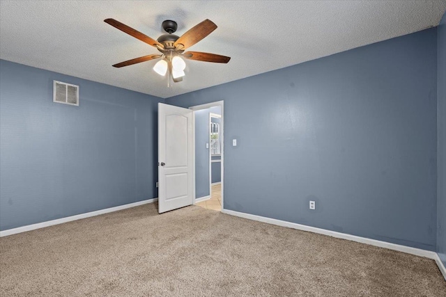 unfurnished room with light carpet and a textured ceiling