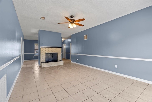 unfurnished living room featuring light tile patterned flooring, a fireplace, ceiling fan, and a textured ceiling