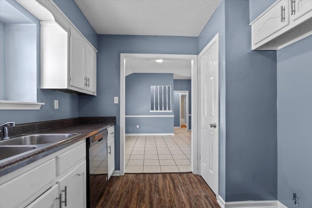 kitchen featuring sink, a textured ceiling, white cabinetry, dishwasher, and dark hardwood / wood-style flooring