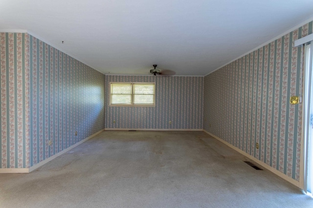 carpeted spare room featuring ceiling fan and crown molding