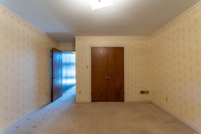 carpeted spare room with crown molding and a textured ceiling