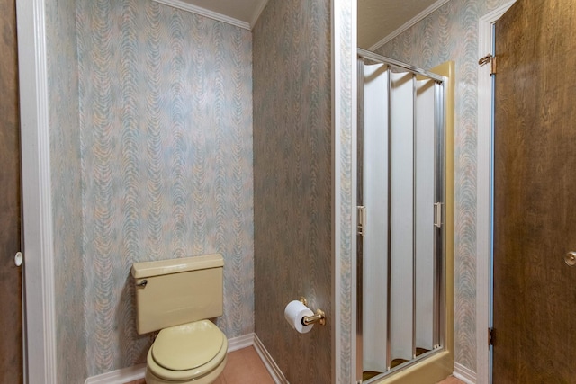 bathroom with ornamental molding, toilet, and a shower with door