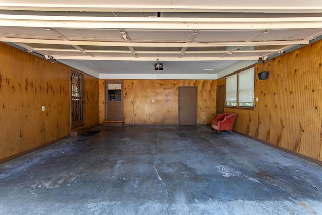 garage featuring a garage door opener and wood walls