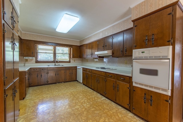 kitchen featuring decorative backsplash, white appliances, crown molding, and sink