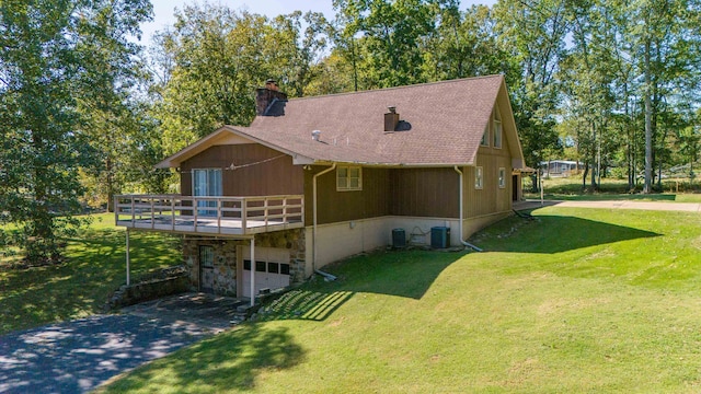 view of side of home featuring central AC unit and a yard