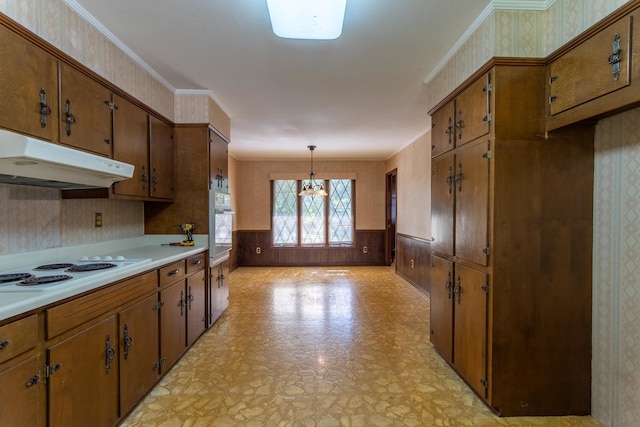 kitchen featuring wooden walls, white appliances, hanging light fixtures, a chandelier, and ornamental molding