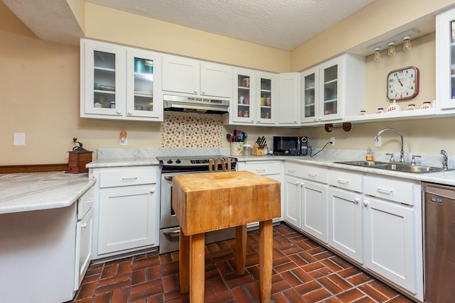 kitchen featuring white cabinets, sink, tasteful backsplash, a textured ceiling, and stainless steel appliances