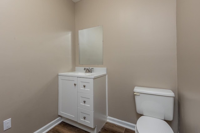 bathroom featuring vanity, hardwood / wood-style floors, and toilet