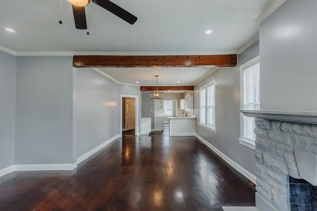 unfurnished living room featuring ceiling fan, a fireplace, crown molding, and dark hardwood / wood-style flooring