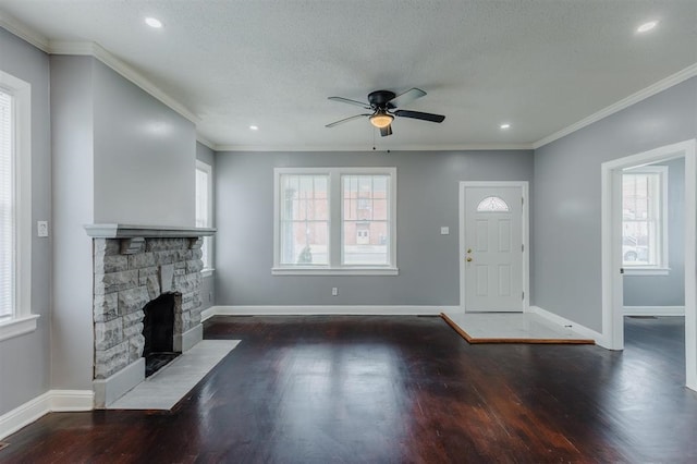 entryway with ornamental molding, a fireplace, ceiling fan, and dark hardwood / wood-style floors