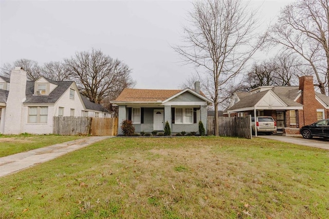 view of front of house with a front lawn, covered porch, and a carport