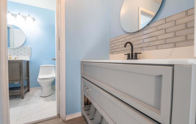 bathroom featuring decorative backsplash, vanity, and toilet