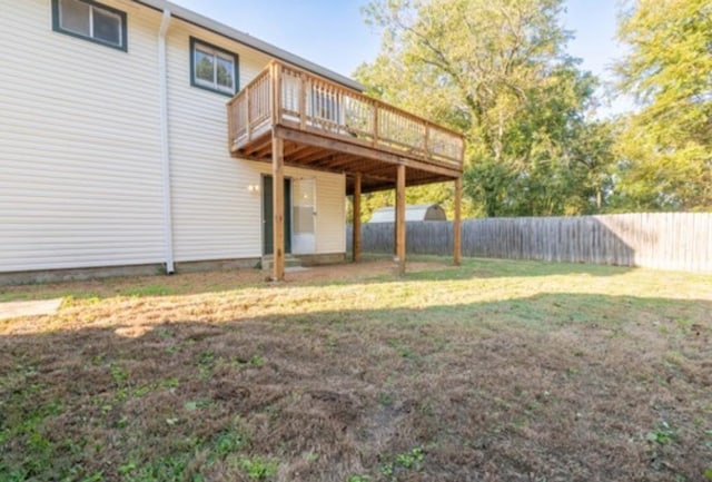 rear view of house with a wooden deck and a yard