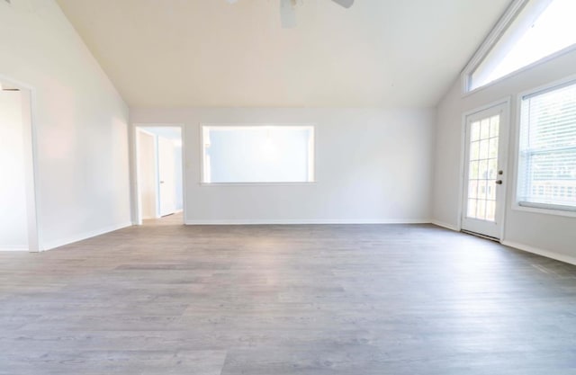 empty room with ceiling fan, light hardwood / wood-style flooring, and lofted ceiling