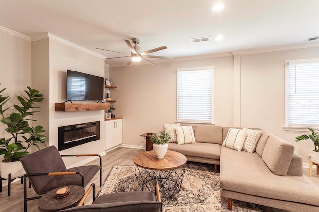 living room featuring hardwood / wood-style flooring, crown molding, and ceiling fan