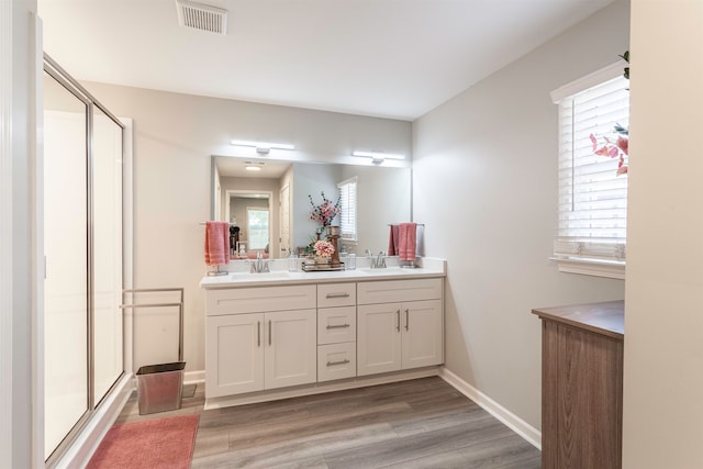 bathroom with vanity, a shower with door, and hardwood / wood-style floors