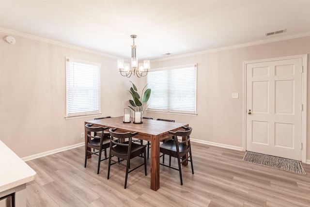 dining area with ornamental molding, a chandelier, and light hardwood / wood-style floors