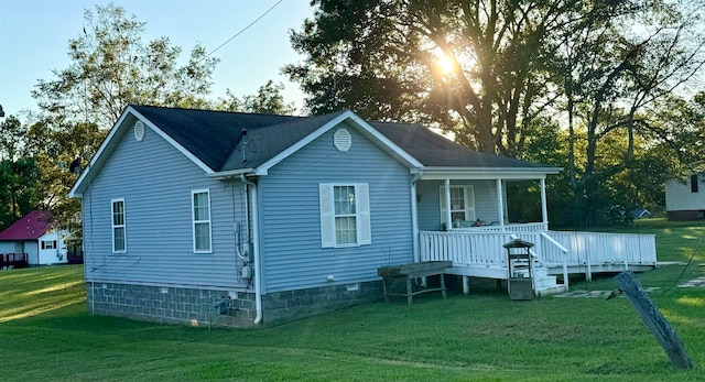 back of house with a deck and a yard