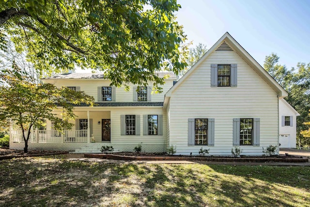 view of front of home with covered porch and a front lawn