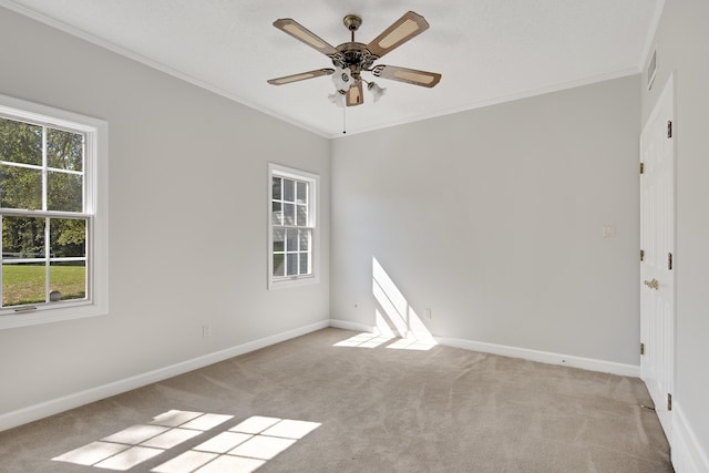 carpeted empty room featuring ceiling fan and crown molding