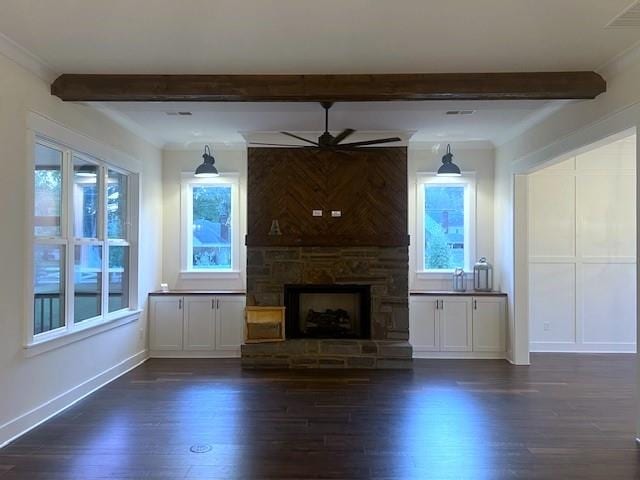 unfurnished living room with beamed ceiling, a wealth of natural light, and dark wood-type flooring