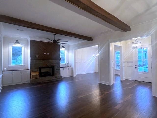 unfurnished living room with a wealth of natural light, beamed ceiling, and dark hardwood / wood-style floors