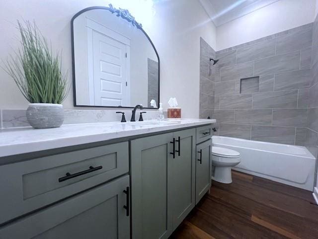 full bathroom featuring tiled shower / bath, hardwood / wood-style floors, vanity, and toilet